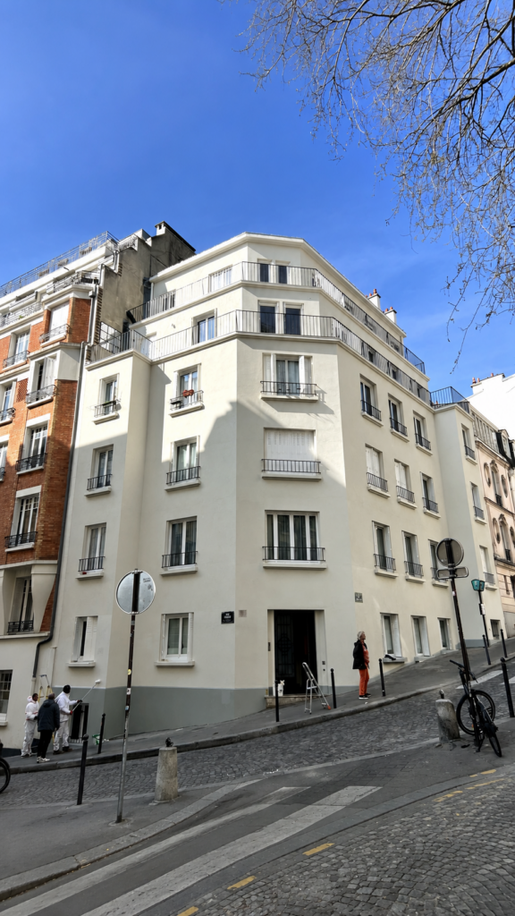 Façade d’un immeuble d’angle dans une rue parisienne.