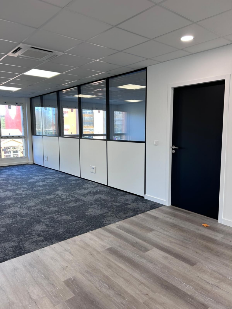 Bureaux rénovés avec cloisons vitrées et faux plafond.