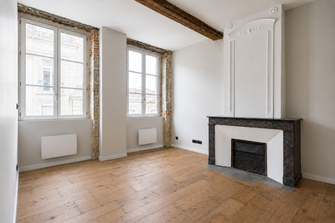 Séjour avec parquet et cheminée après rénovation.